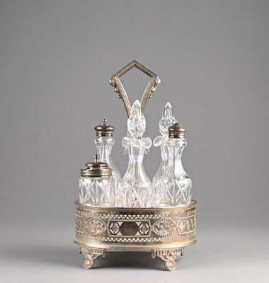 an antique silver and glass decanter with four bottles on a stand