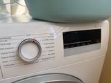a washing machine with a bowl on top of it
