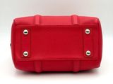 the red purse is sitting on a white surface