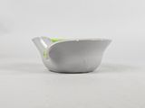 a close up of a small white bowl on a white surface