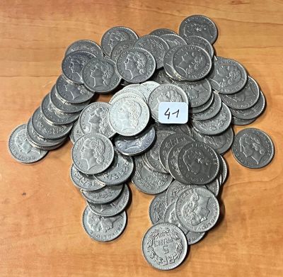 un tas de pièces d'argent posées sur une table en bois