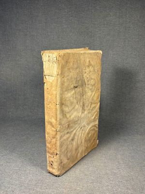an old book sitting on top of a table next to a gray background