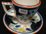 une petite tasse et une soucoupe ornées d'un chat