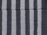 a close up of a black and white striped shirt with a yellow button