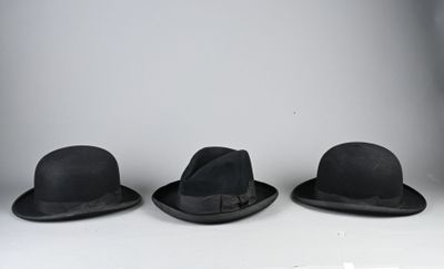 trois chapeaux sont alignés sur une étagère dans une pièce blanche