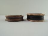 two black and gold containers sitting on a white surface