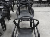 des rangées de chaises noires dans un entrepôt, avec une étiquette de prix au dos