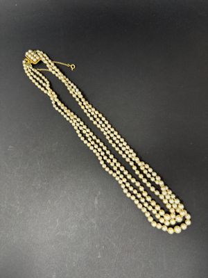 a gold and pearl necklace with three strands of pearls