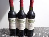 trois bouteilles de vin rouge posées sur une table