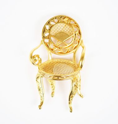 chaise miniature plaquée or sur fond blanc, avec un fond blanc