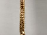 gros plan d'un bracelet en chaîne en or sur fond blanc