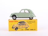 une petite voiture verte posée sur une boîte jaune