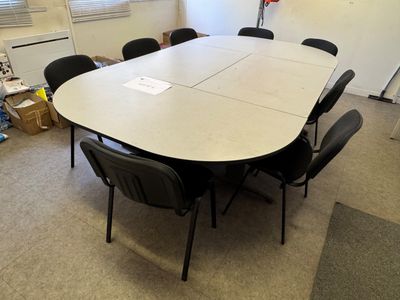une grande table entourée de chaises dans une pièce