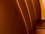two brown leather chairs sitting next to each other in a room