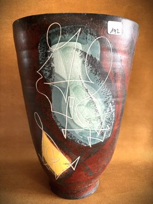 a vase with a painting on it sitting on a table