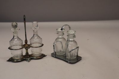 two small glass bottles and a metal holder on the table