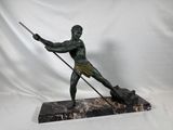statue d'un homme tenant une lance et accompagné d'un chien, posée sur un socle en marbre