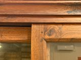 un gros plan d'une armoire en bois avec une porte vitrée