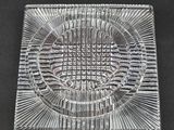 a clear glass ashtray with a circular design on it