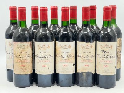 six bouteilles de vin rouge alignées sur une surface blanche