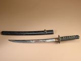 une paire de vieux sabres de samouraï japonais exposés sur un fond beige