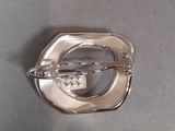a silver brooch that is on a table