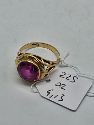 purple stone ring with a price tag on a white surface