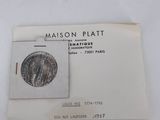 an image of a piece of silver coin on a piece of paper