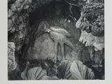 an old black and white photo of a man in a cave