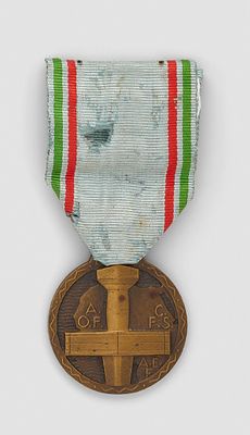 an old medal with a cross on it sitting on a white surface