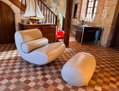 a white chair and ottoman in a room with a checkered floor