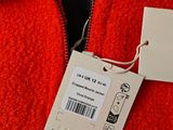 a label on a red jacket with a tag attached to it
