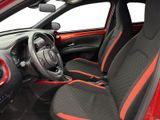 the interior of a small car with red trims and black seats