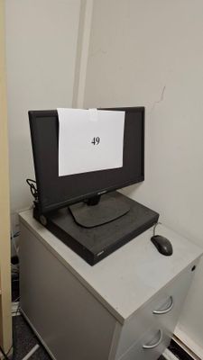 a computer monitor sitting on top of a filing cabinet