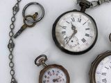 many different types of pocket watches on the table