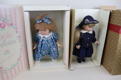 deux poupées qui se trouvent dans une boîte posée sur une table