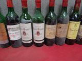 plusieurs bouteilles de vin sont alignées sur une table rouge