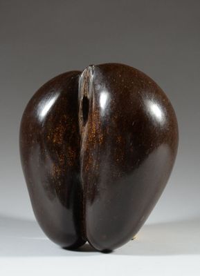 sculpture représentant une aubergine fendue en son milieu, posée sur une surface blanche