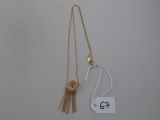 two necklaces and a tag on a white surface