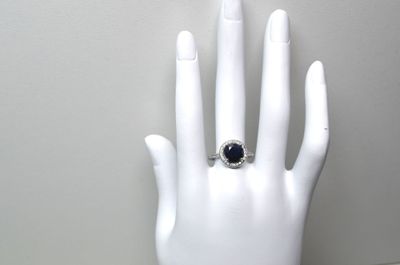 une main portant une bague, posée sur un mannequin