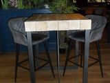 a table with two chairs and a plant in the background