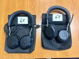 two black headphones sitting on top of a table next to each other
