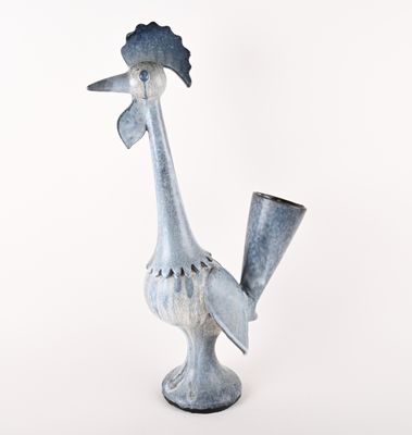 a small metal rooster with a hat on it ' s head