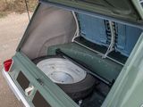 a green car with a flat tire in the back of it