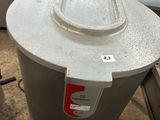 un grand réservoir métallique sur lequel se trouve un bouton rouge