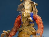 a figurine of a woman with a bird on her shoulder