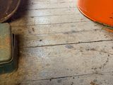 an orange bucket sitting on the floor next to a window