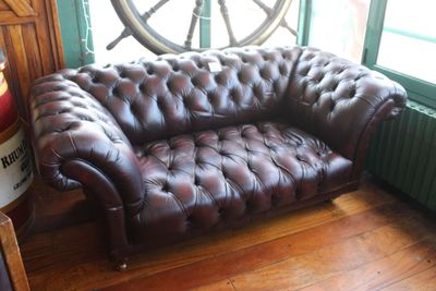 un canapé en cuir marron placé devant une fenêtre