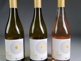 trois bouteilles de vin posées l'une à côté de l'autre sur une table