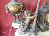 a statue of a boy holding a clock and a pole